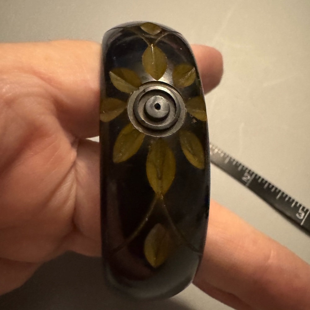 Bakelite black and gold sunshine or flowers engraved in